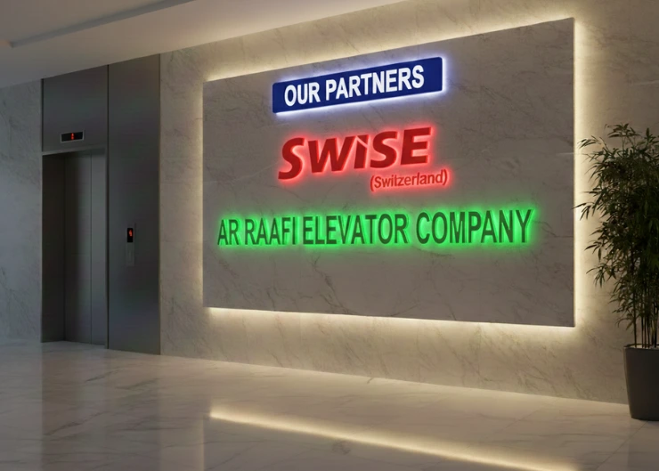 An office lobby featuring a marble feature wall with the "SWISE (Switzerland)" logo and "AR RAAFI ELEVATOR COMPANY" in lettering under an "OUR PARTNERS."